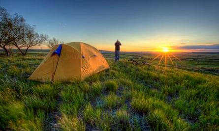 Person looking through binoculars and camping in Grasslands National Park, Saskatchewan, Canada.